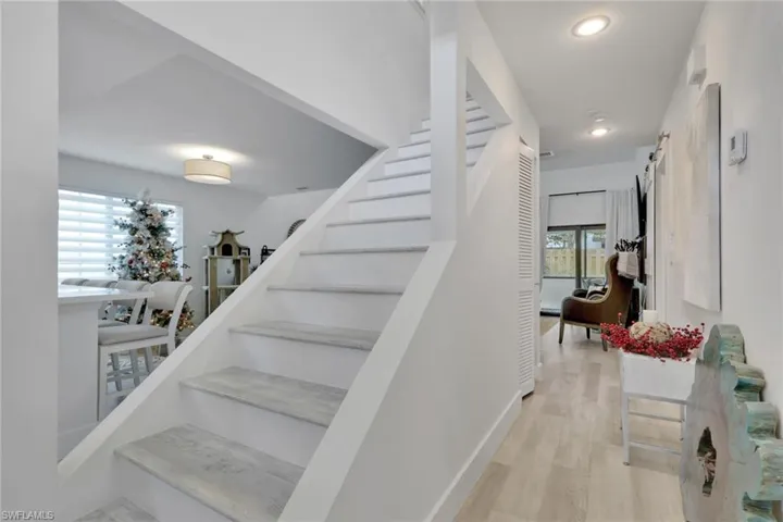 Stairs with wood finished floors and recessed lighting