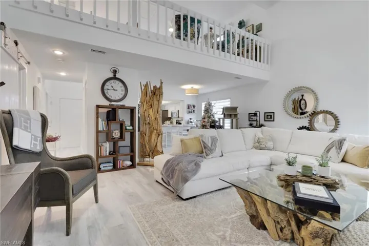 Living area with light wood-style floors and a towering ceiling