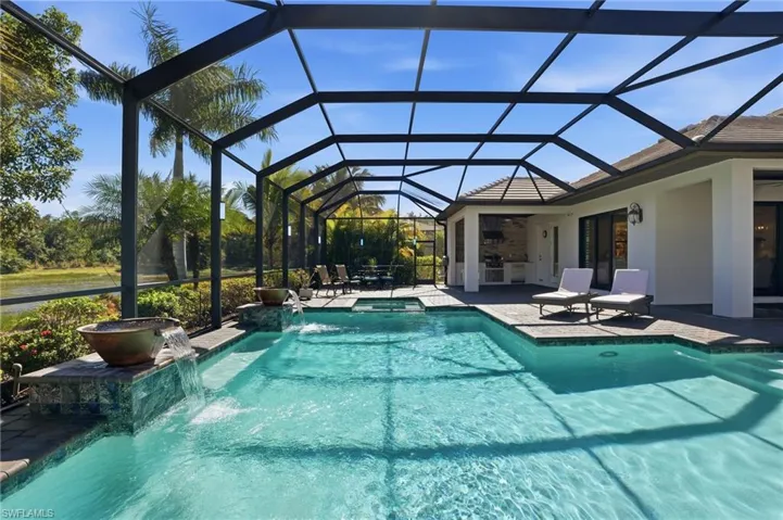 View of pool with a patio area, a lanai, a sunroom, and a pool with connected hot tub