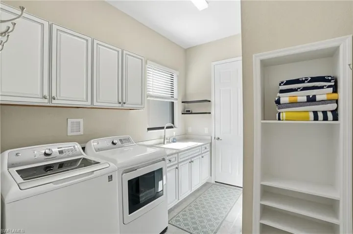 Washroom with washer and dryer and cabinet space