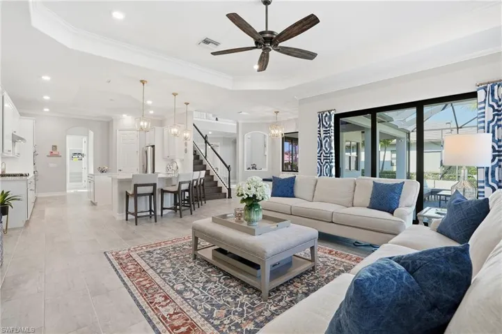 Living area with a ceiling fan and ornamental molding