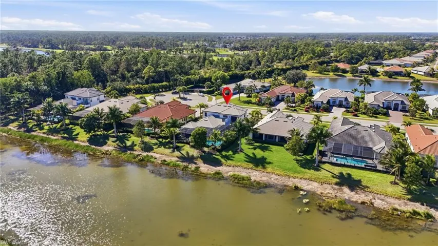 Aerial view of property and surrounding area featuring a large body of water and nearby suburban area