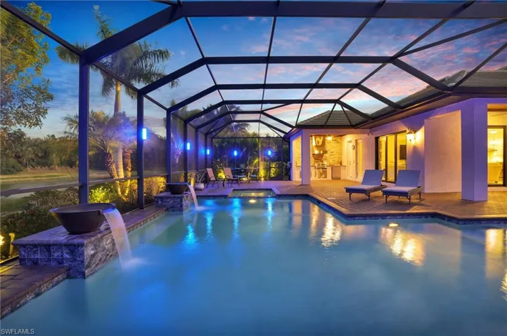 Swimming pool with glass enclosure, an in-ground hot tub, a sunroom, and area for grilling