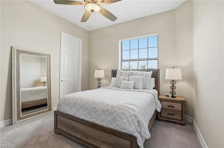 Carpeted bedroom featuring baseboards and ceiling fan