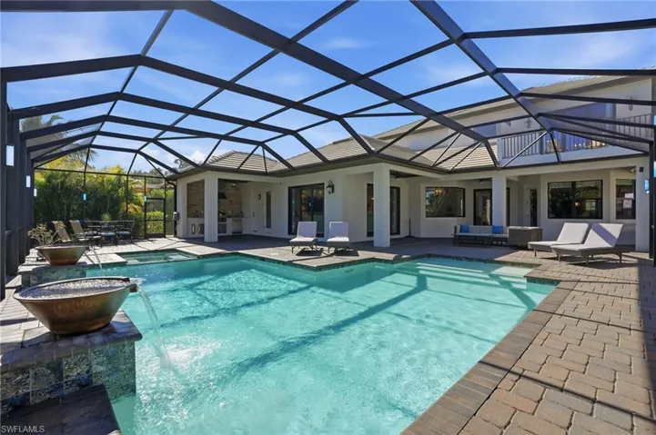 View of swimming pool with a sunroom, a lanai, a patio area, and a pool with connected hot tub