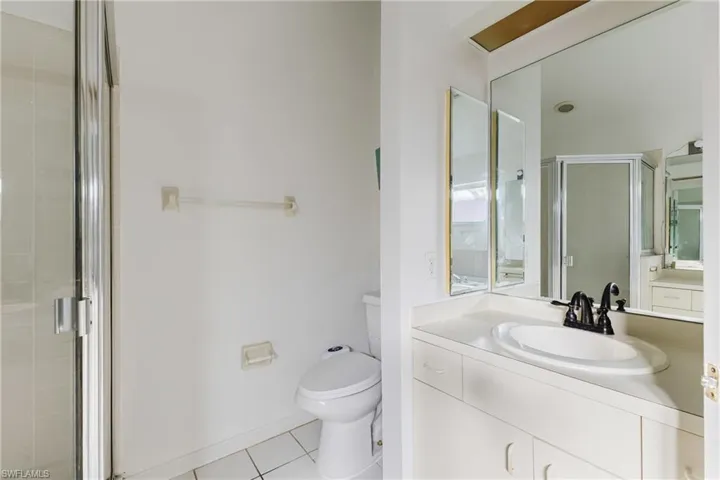 Full bath with vanity, a stall shower, and light tile patterned flooring