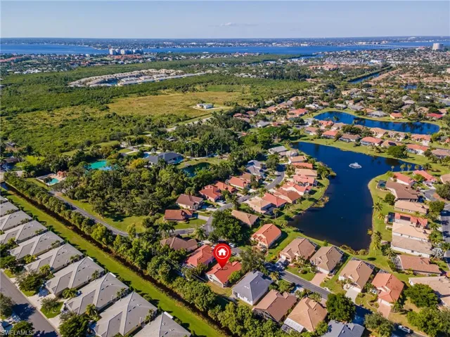 Aerial view of property and surrounding area featuring a large body of water and nearby suburban area