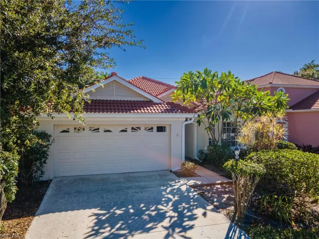 View of front of house featuring stucco siding, driveway, a garage, and a tiled roof
