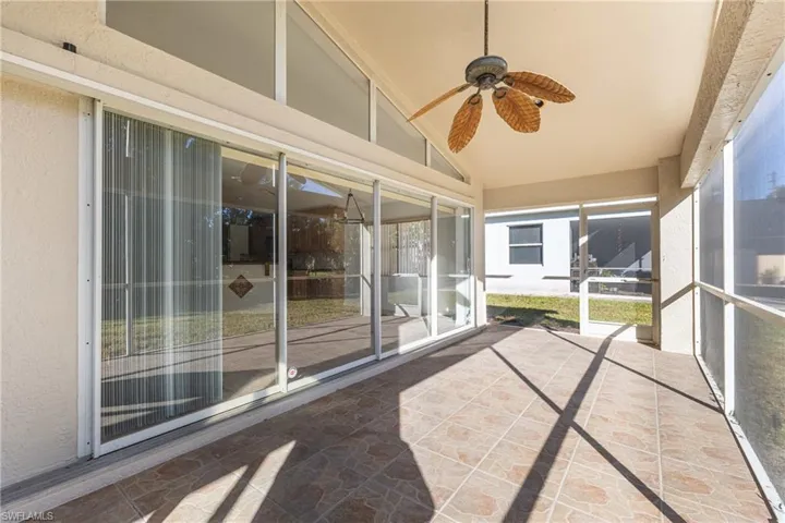 Unfurnished sunroom featuring a ceiling fan and vaulted ceiling