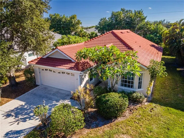 View of front of home with stucco siding, an attached garage, driveway, and a tile roof