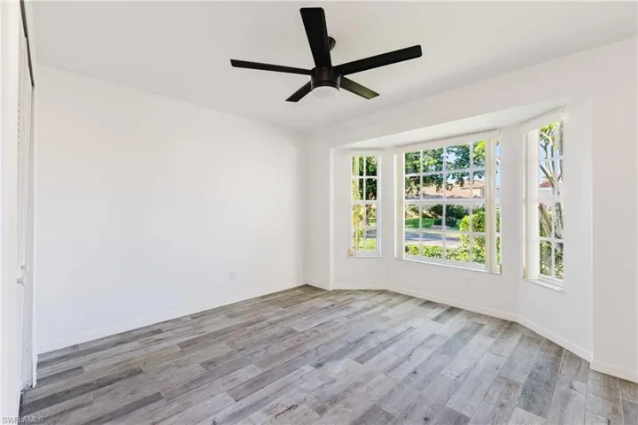 Empty room with light wood-style flooring and ceiling fan