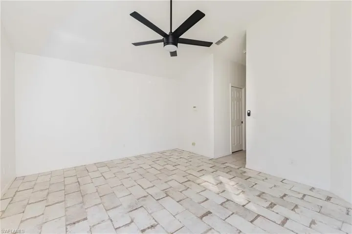 Unfurnished room featuring a ceiling fan and lofted ceiling
