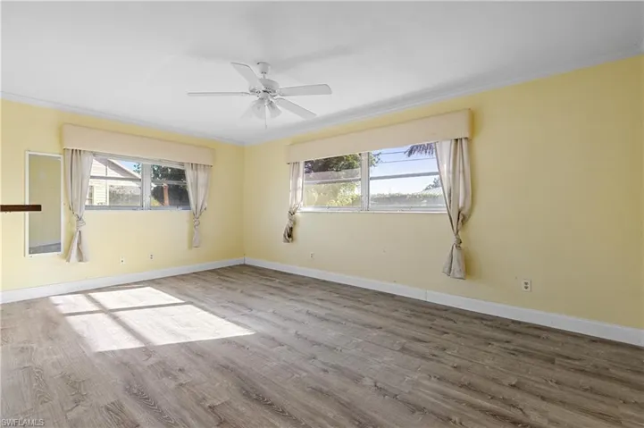 Unfurnished room with crown molding and plenty of natural light