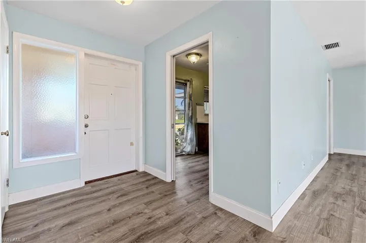Entrance foyer featuring visible vents, baseboards, and wood finished floors