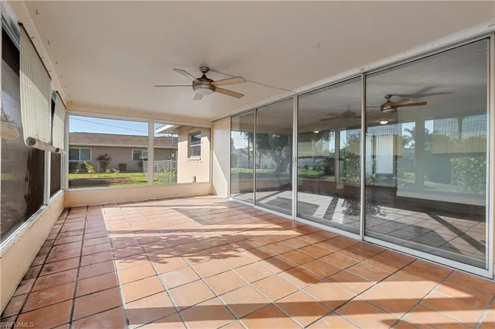 Unfurnished sunroom featuring a ceiling fan