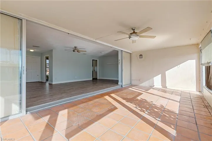 Empty room featuring baseboards, ceiling fan, and light tile patterned floors