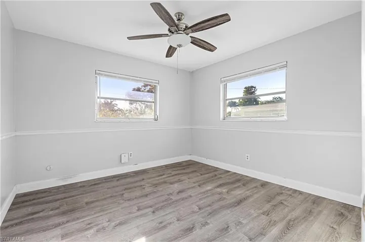 Spare room with baseboards, ceiling fan, and wood finished floors