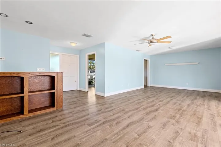 Unfurnished living room featuring baseboards, ceiling fan, wood finished floors, and visible vents