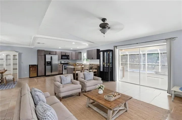 Open-concept living space featuring a modern kitchen with wood-finish cabinetry and stainless steel appliances