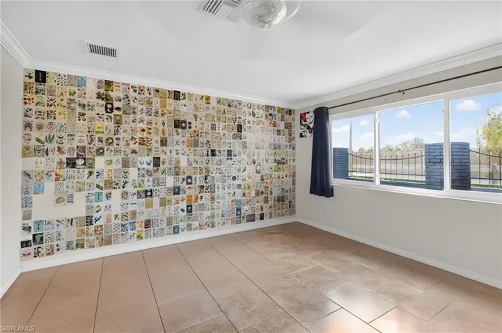 Spacious room featuring large format tile flooring and crown molding