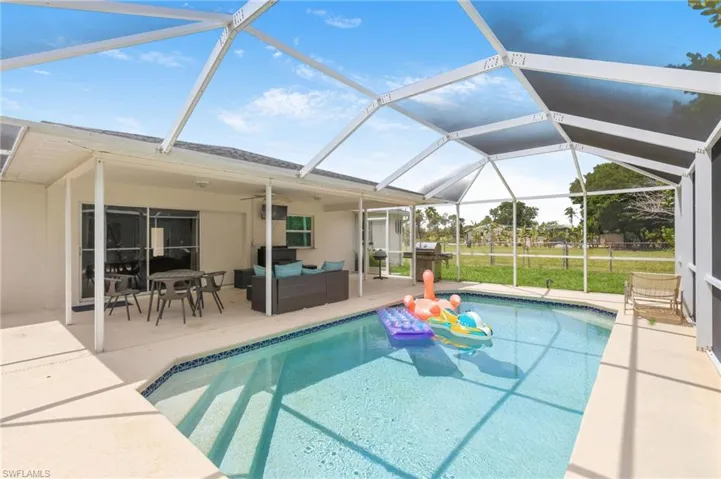 Screened-in pool area featuring a concrete deck, tiled pool, and a covered patio with sliding glass doors