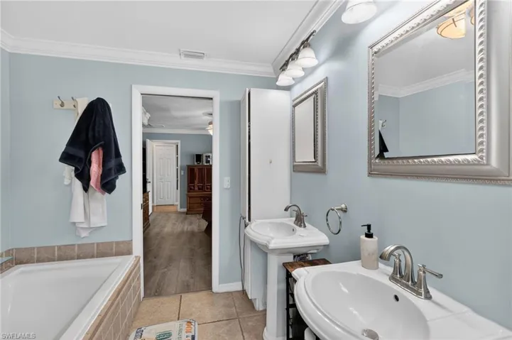 Bathroom featuring two pedestal sinks with chrome fixtures