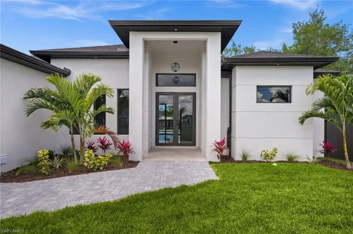 Modern contemporary exterior with a prominent covered entryway, double glass entry doors, and a paver pathway