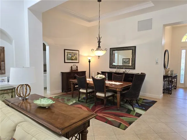 Dining room with crown molding and light tile