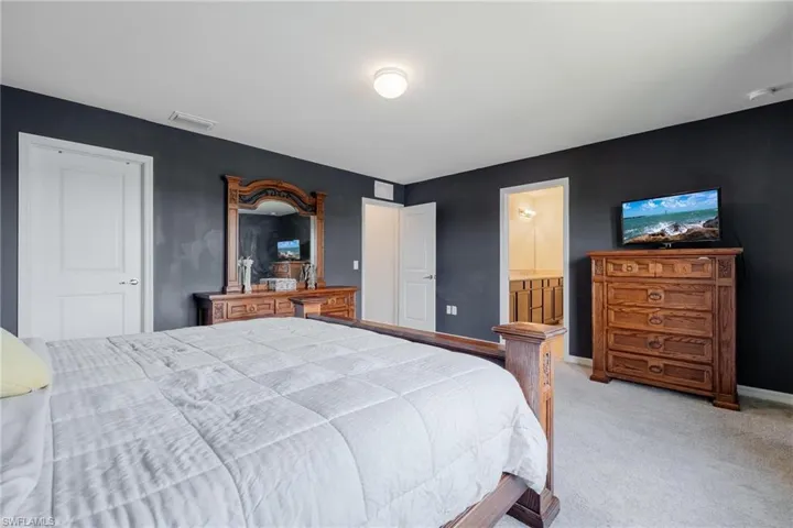 Carpeted bedroom featuring connected bathroom