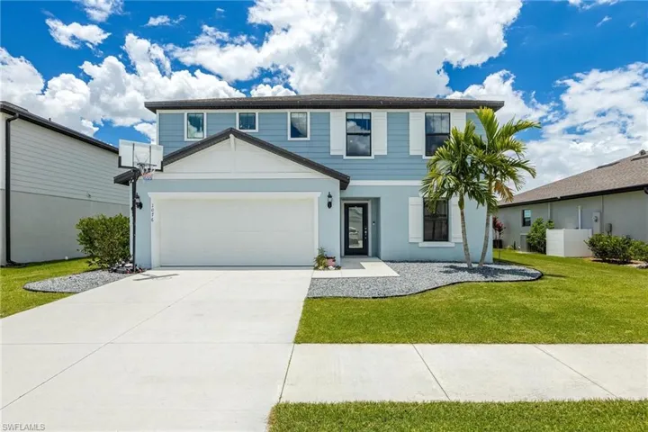 View of front of house with a garage and a front yard