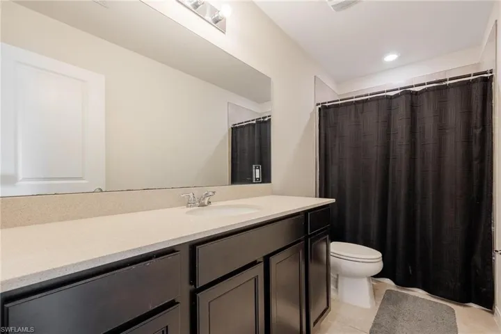 Bathroom with tile flooring, vanity, and toilet