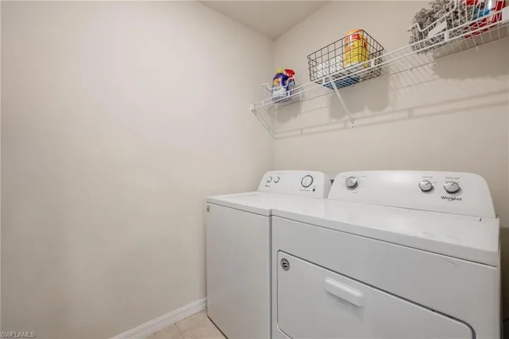 Laundry room featuring separate washer and dryer and light tile flooring