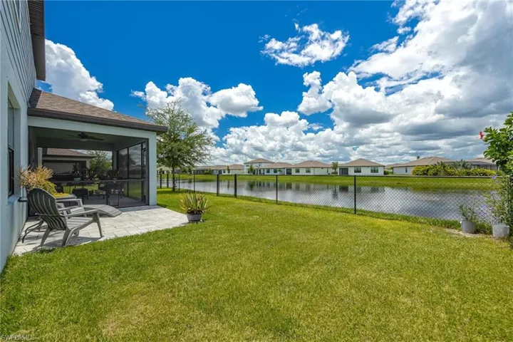 View of yard featuring ceiling fan, a patio area, and a water view