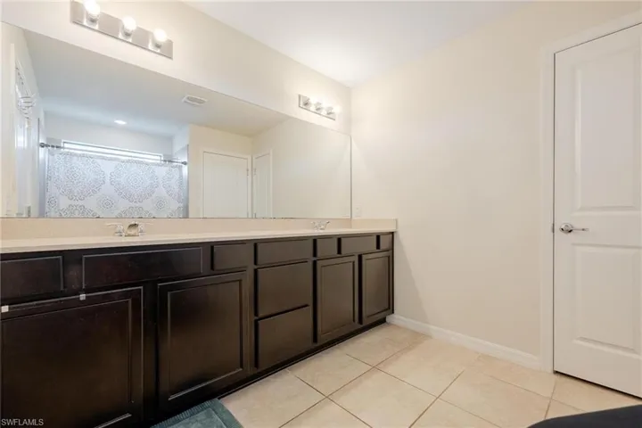 Bathroom featuring double vanity and tile floors