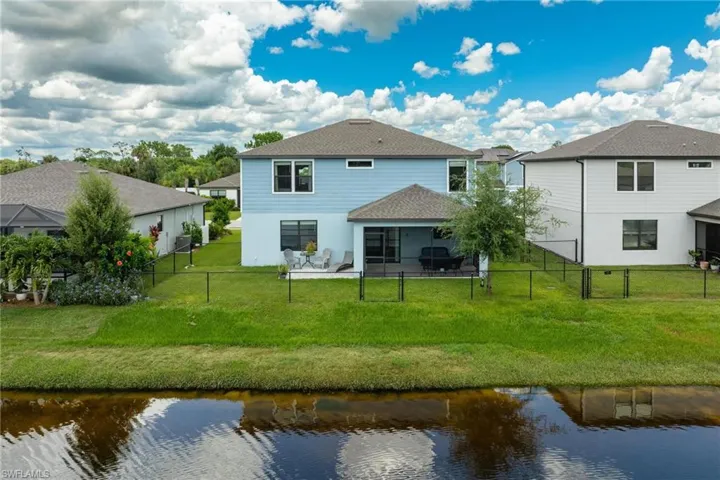 Rear view of property featuring a water view and a yard