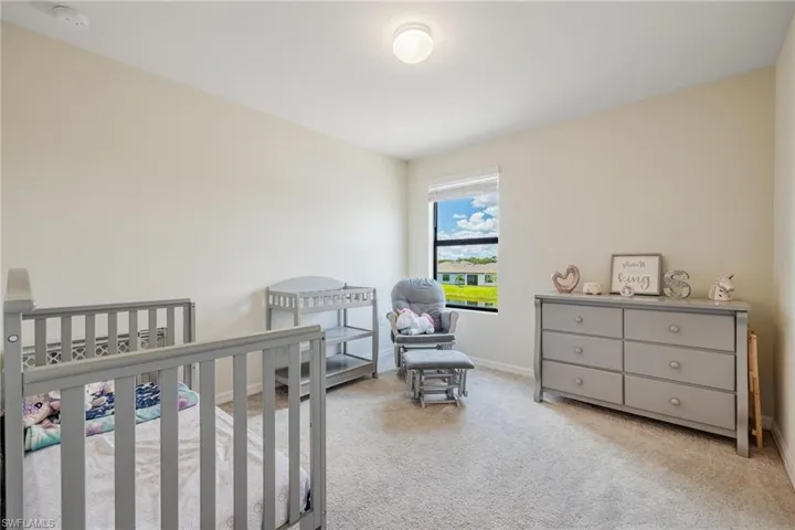 Bedroom with a crib and light colored carpet