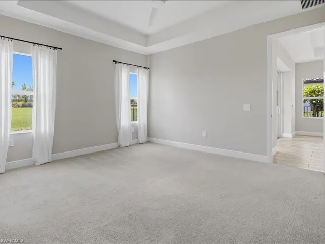 Spacious room featuring light gray walls and plush carpeting