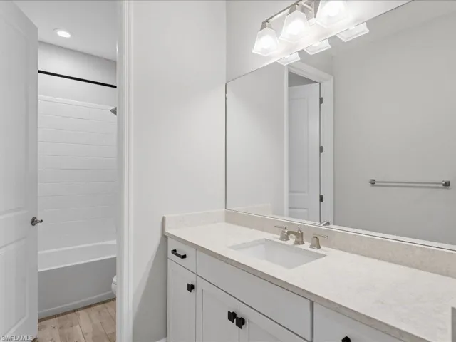 Bathroom vanity featuring a light-colored countertop, undermount sink, and brushed nickel faucet