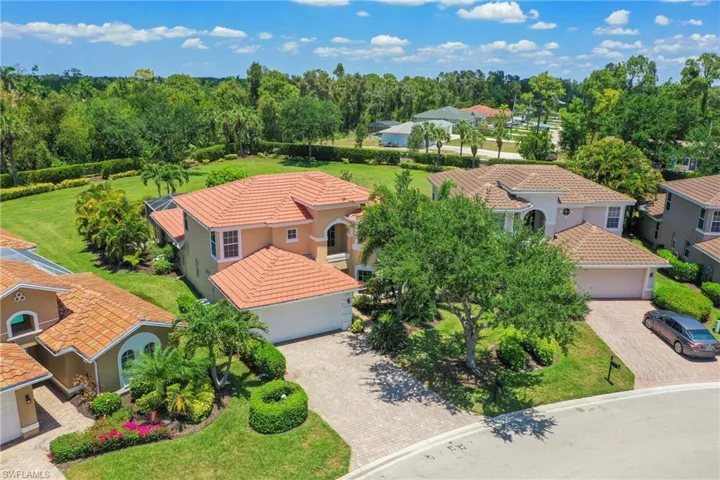 Mediterranean-style residence featuring a terracotta-hued tile roof, an integrated two-car garage, and a paver driveway