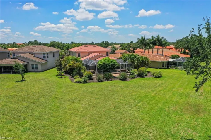 Expansive green lawn with mature landscaping and tropical trees