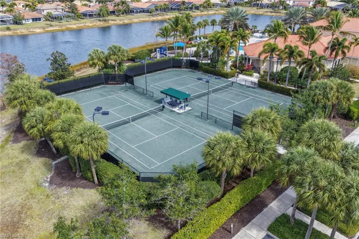 Two hard-surface tennis courts featuring perimeter fencing and court lighting