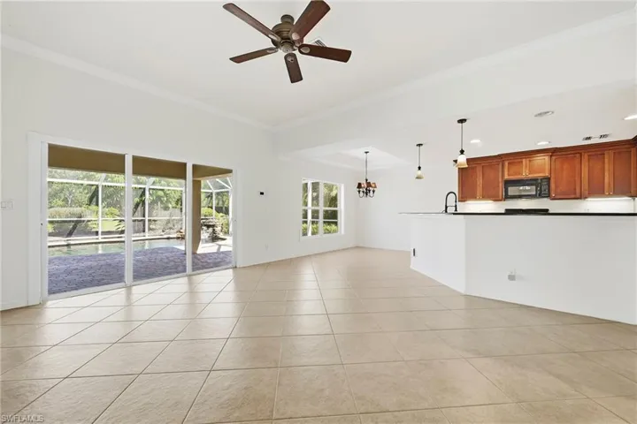 Open concept living area with tiled flooring and crown molding
