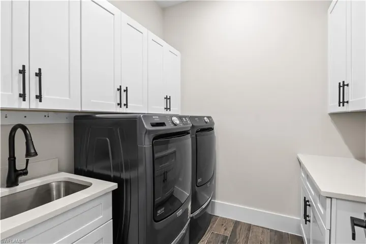 Spacious laundry area equipped with a handy sink, making chores easier and providing extra functionality for all your cleaning needs.