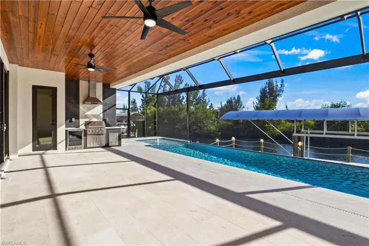 Outdoor kitchen with expansive under cover lanai with cypress ceilings, a pool, spa and boatlift!