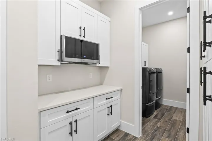 A thoughtfully designed butler’s pantry paired with a laundry room enhances storage and daily efficiency.