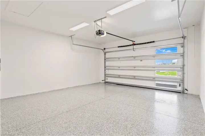 Completing the pair, the second two-car garage offers additional space for a total of four vehicles. Newly finished epoxy flooring provides a sleek, durable surface. Both garages feature 8-foot steel overhead doors, equipped with automatic openers and keyless entry for modern ease and functionality.