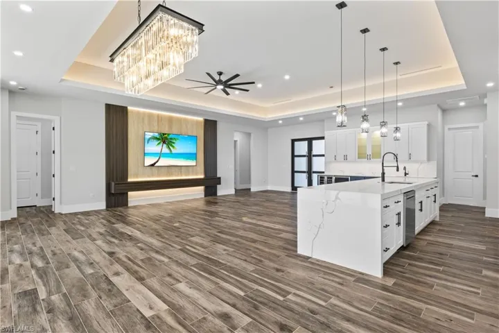 Another view of the expansive great room - ceramic plank floor, travertine accent wall with custom wood detail and lighting!