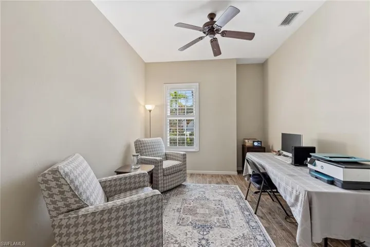 Office space with visible vents, baseboards, ceiling fan, and wood finished floors
