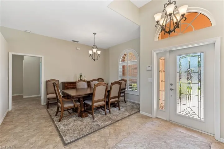 Dining area with tile patterned floors, a notable chandelier, baseboards, and visible vents
