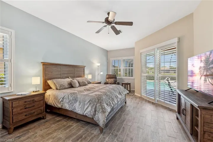 Bedroom featuring access to exterior, multiple windows, and dark wood-type flooring